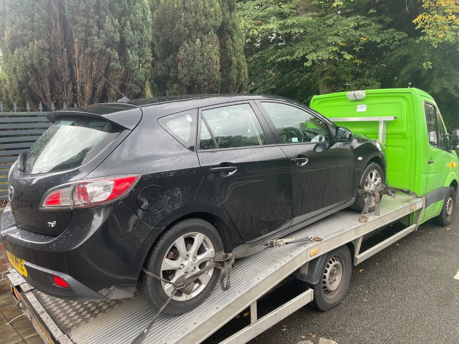 Black car on recovery truck